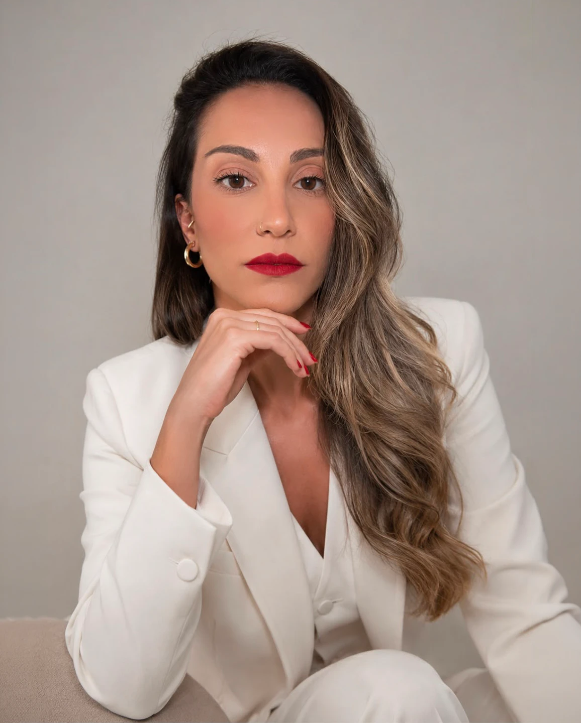 Dra. Thais Fonseca, retrato editorial com blazer branco e fundo neutro